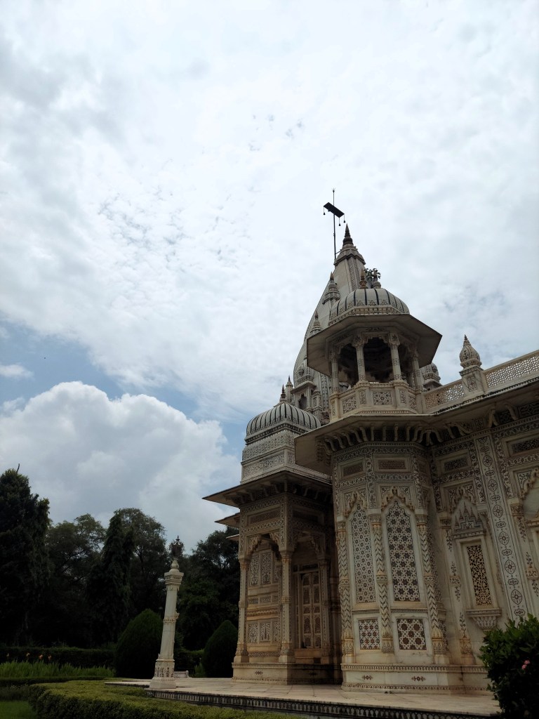 The spire of a marble cenotaph touches the clouds.