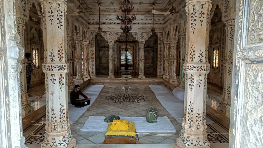 Inside a marble cenotaph, an Indian man practices Hindustani classical music with a harmonium.